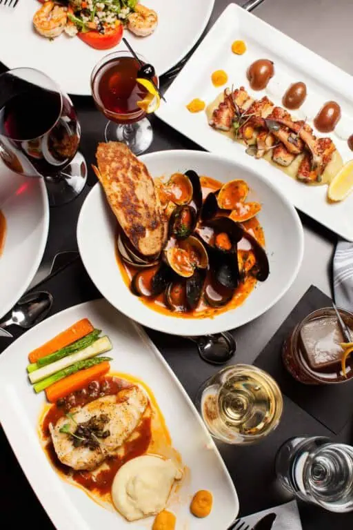 Assortment of gourmet dishes and beverages on table.