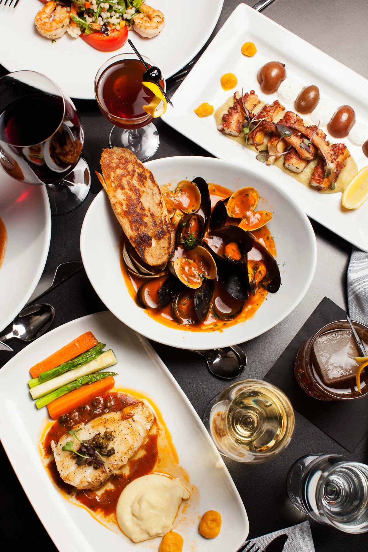 Assortment of gourmet dishes and beverages on table.