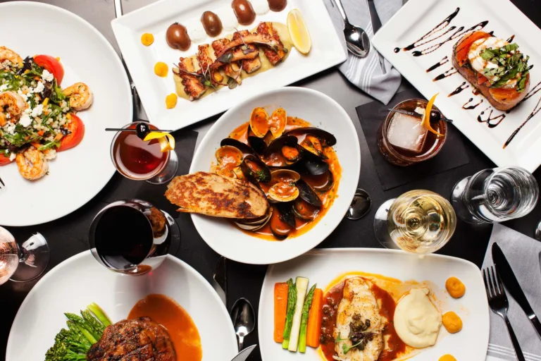 Gourmet meal with seafood, steak, and drinks.