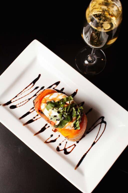Caprese bruschetta with balsamic glaze and white wine