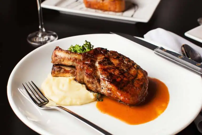 Grilled pork chop with mashed potatoes and gravy.