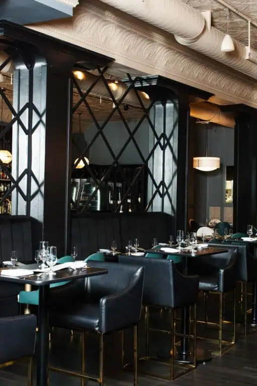 Modern, elegant restaurant interior with black leather seating.